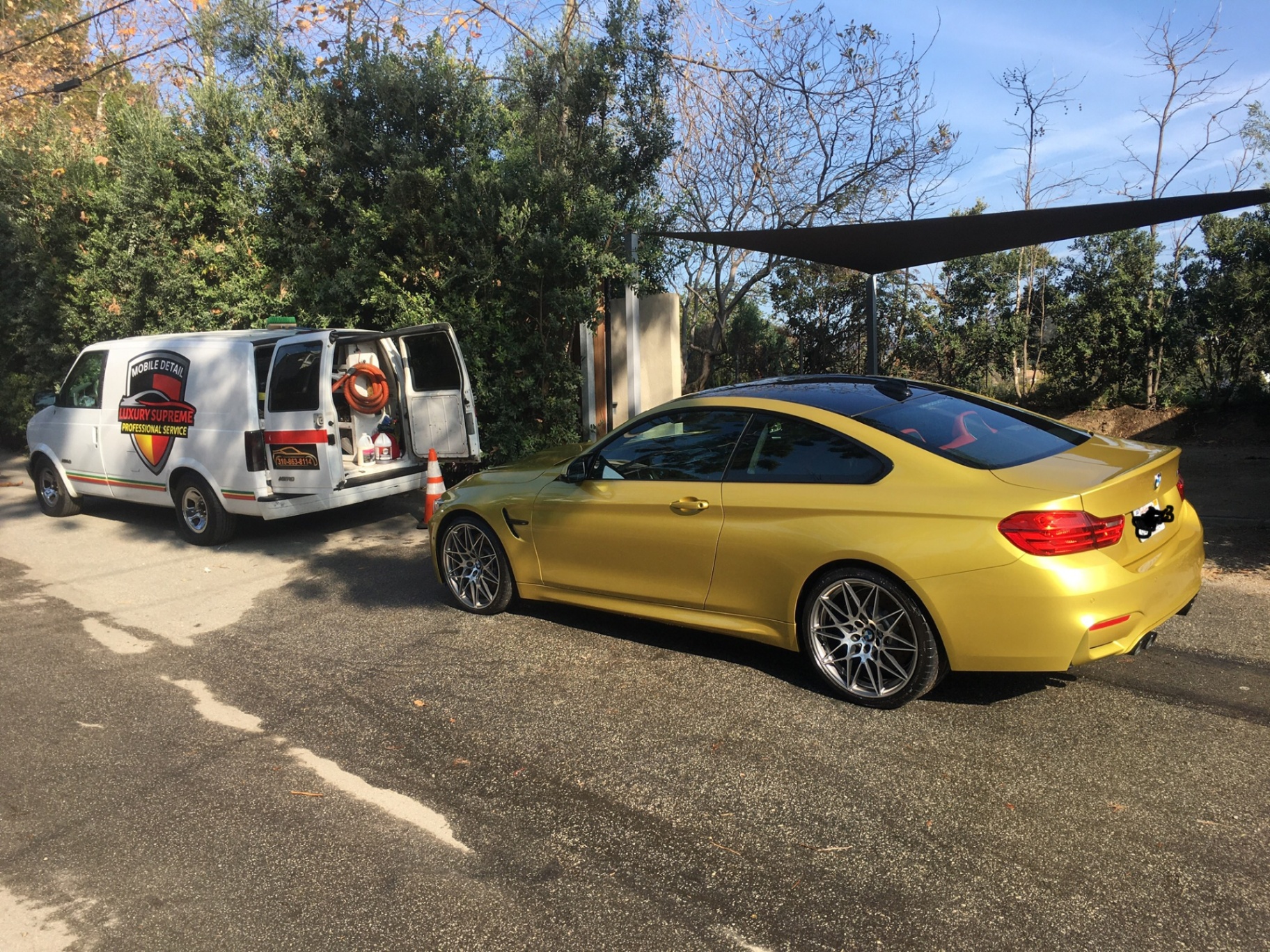 Gold BMW coupe with mobile detailing van