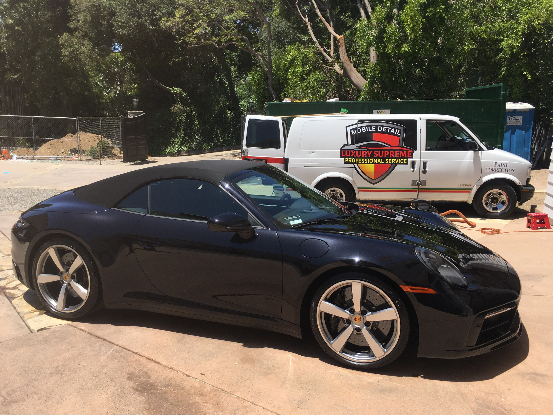 Black Porsche 911 Cabriolet with service van